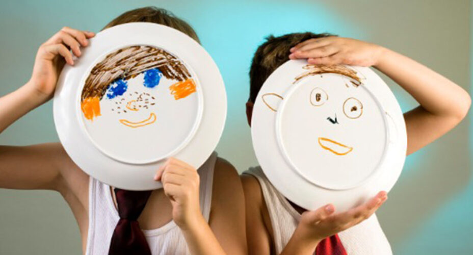 Young boys in undershirt and ties with a faces painted on a plates.